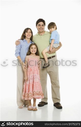 Hispanic family standing against white background.
