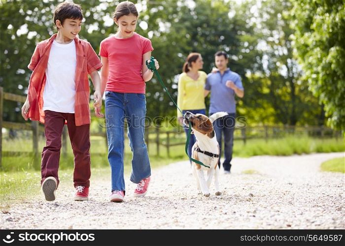 Hispanic Family Taking Dog For Walk In Countryside