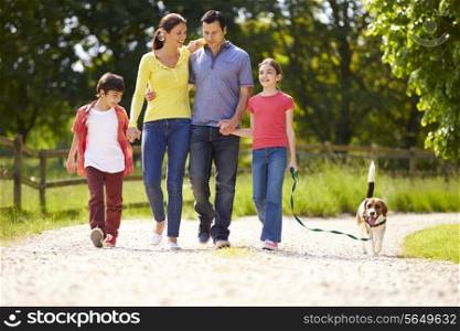 Hispanic Family Taking Dog For Walk In Countryside