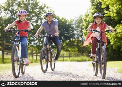 Hispanic Father And Children On Cycle Ride In Countryside