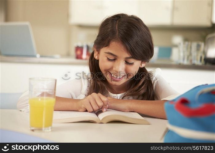 Hispanic Girl With Reading Homework At Table