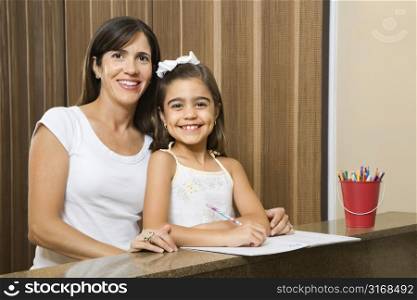 Hispanic mother and daughter portrait with homework.