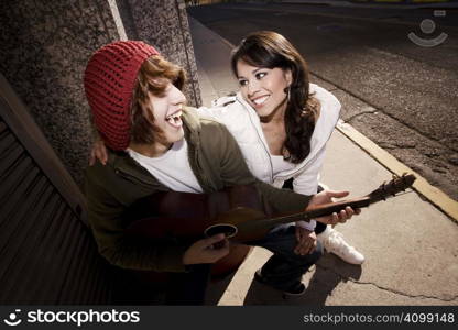 Hispanic musician and Latina Girlfriend downtown at sundown