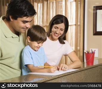 Hispanic parents helping son with homework.
