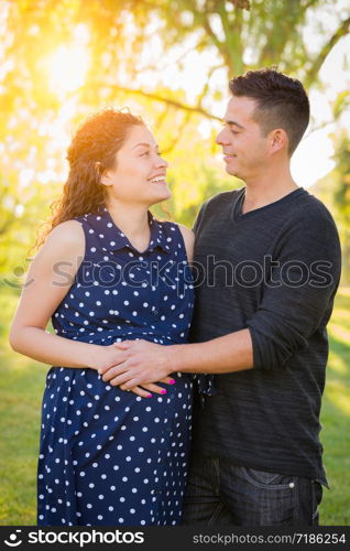 Hispanic Pregnant Young Couple Portrait Outdoors.