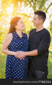 Hispanic Pregnant Young Couple Portrait Outdoors.