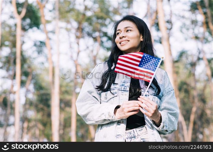 hispanic teenage girl holding american flag stick