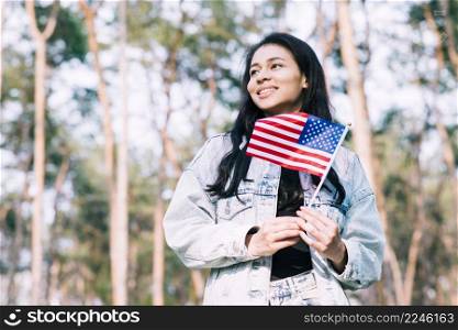 hispanic teenage girl holding american flag stick