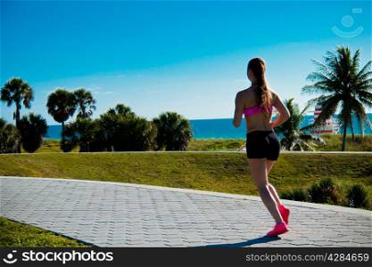 Hispanic woman jogging in a tropical setting