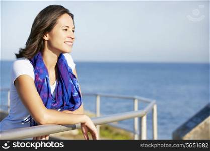 Hispanic Woman Looking Over Railing At Sea