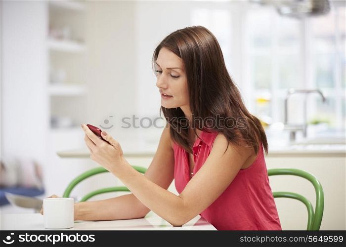 Hispanic Woman Sending Text Message At Home