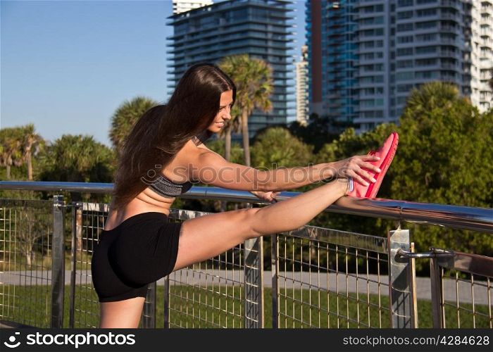 Hispanic woman stetching before jogging
