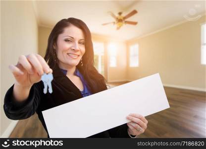 Hispanic Woman With House Keys and Blank Sign In Empty Room of House.
