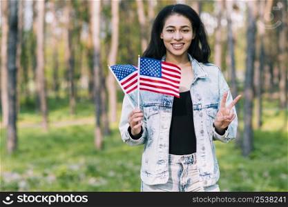 hispanic woman with usa flags showing peace gesture