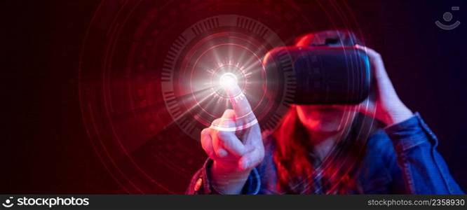 Hispanic woman with virtual reality goggles with digital technology exploring cyberspace in 3D with blue and red light while pressing a light button with her finger. Hispanic woman with virtual reality goggles with digital technology exploring cyberspace in 3D with blue and red light while pressing a button with her finger