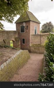 Historic alley with watchtower and gate in the ancient city wall downtown Hattem, the Netherlands.