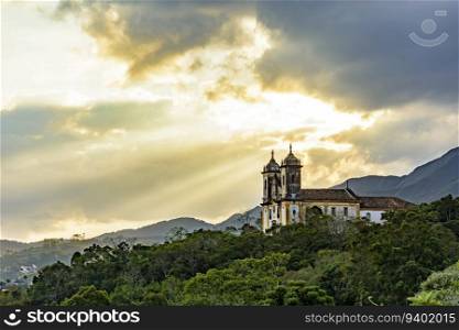 Historic baroque church on top of the hill and among the vegetation in the city of Ouro Preto in Minas Gerais. Historic baroque church on top of the hill