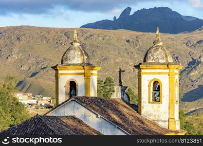 Historic church tower in baroque architecture with mountains in the background in Ouro Preto, Minas Gerais. Historic church tower in baroque architecture with mountains