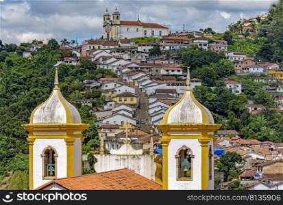Historic city of Ouro Preto in Minas Gerais, Brazil with its slopes, hills and churches seen through the old church towers. Ouro Preto city with its slopes, hills and churches seen through the old church towers 