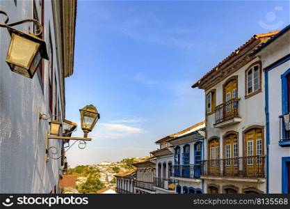 Historic city of Ouro Preto in Minas Gerais with its colonial architecture houses, lanterns and a church in the background. Historic city of Ouro Preto in Minas Gerais with its colonial architecture
