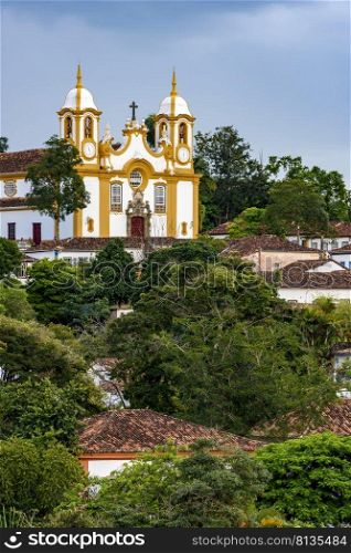 Historic colonial-style church surrounded by houses and greenery in the city of Tiradentes in Minas Gerais, Brazil. Historic colonial-style church surrounded by houses in the city of Tiradentes 