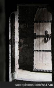 Historic heavy wooden door studded with black iron