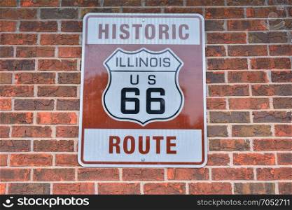 Historic Route 66 road sign painted on a brick wall in Illinois