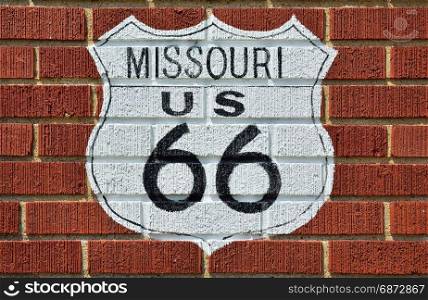 Historic Route 66 road sign painted on a brick wall in Missouri