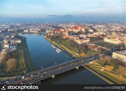 Historic royal Wawel castle in Cracow, Poland with park and Vistula river. Aerial view at sunset.