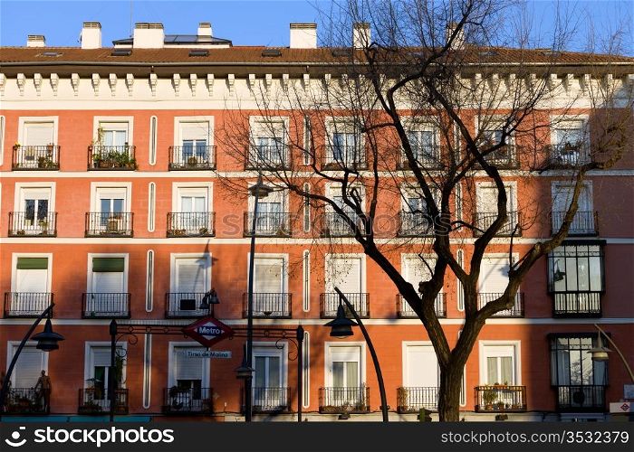 Historic tenement house facade architecture at the Plaza Tirso de Molina in Madrid, Spain.