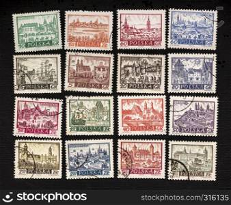 historical representation of famous Polish cities - a set of vintage caceled post stamps on black canvas