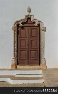 Historically church door of the Alvor Mother Church dedicated to divine Savior, Alvor, Portugal.