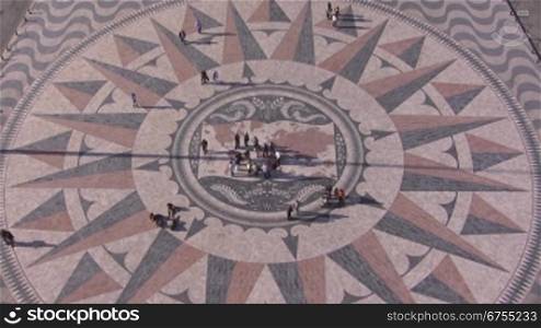 Historischer Platz aus Stein-Mosaik in Lissabon. Denkmal der Entdecker. Es stellt die Weltkarte dar und die wichtigsten Entdeckerreisen sind eingezeichnet. Menschen sind auf dem Platz.
