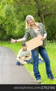 Hitch-hike young couple backpack tramping on asphalt road play guitar