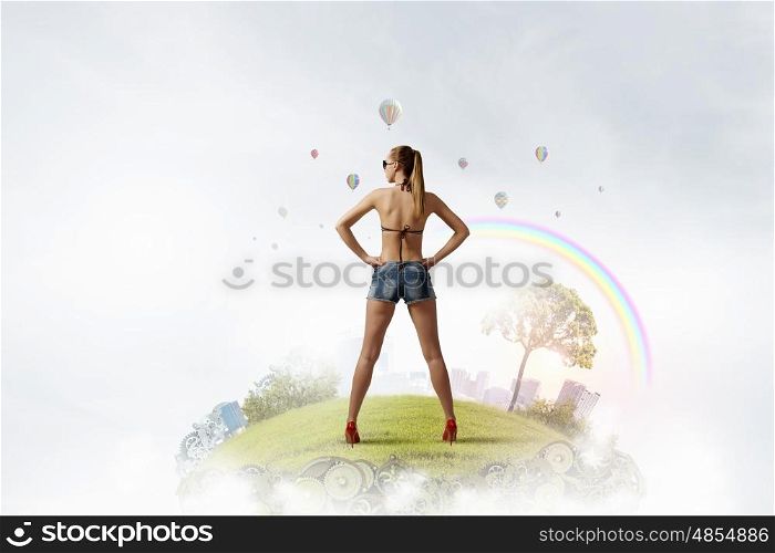 Hitch hiker woman on hill. Beautiful woman in swimsuit standing with arms on waist