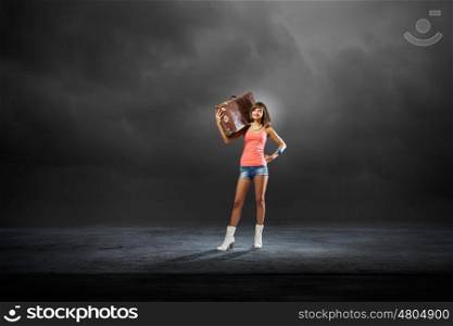 Hitch hiking traveling. Young retro woman with her vintage baggage on shoulder