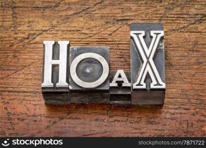 hoax word in mixed vintage metal type printing blocks over grunge wood