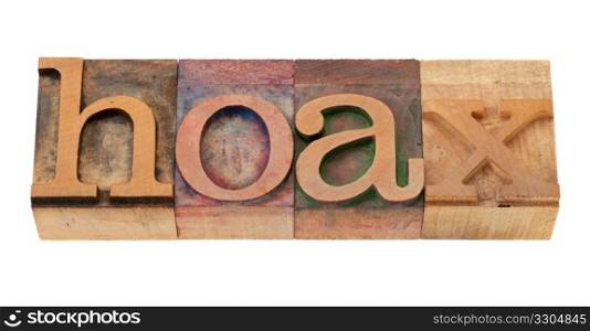 hoax - word in vintage wooden letterpress printing block, stained by color inks, isolated o n white