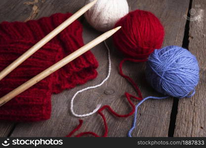 hobby. knitting - set of multicolored balls threads and knitting needles on a wooden table