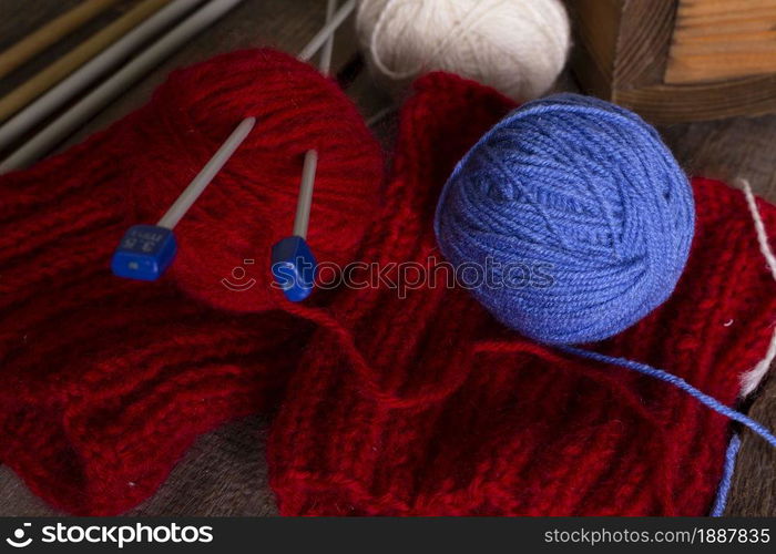 hobby. knitting - set of multicolored balls threads and knitting needles on a wooden table