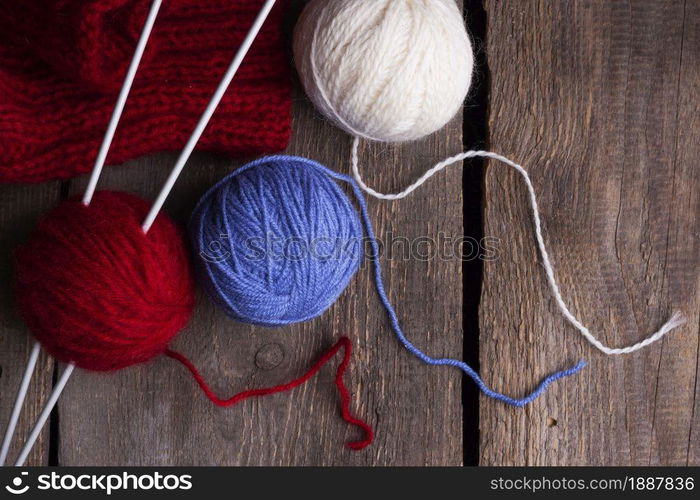 hobby. knitting - set of multicolored balls threads and knitting needles on a wooden table