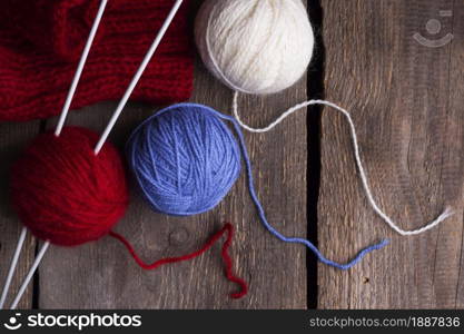 hobby. knitting - set of multicolored balls threads and knitting needles on a wooden table