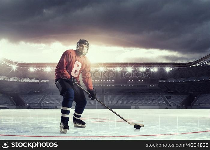 Hockey player on ice mixed media. Hockey player in on ice rink in spotlight