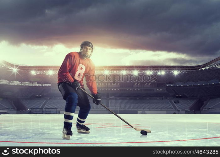 Hockey player on ice mixed media. Hockey player in on ice rink in spotlight