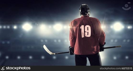 Hockey player on ice mixed media. Hockey player in red uniform on ice rink in spotlight