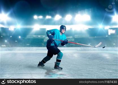 Hockey player with stick and puck makes a throw, ice arena, spotlights on background. Male person in helmet, gloves and uniform playing game