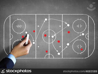 Hockey strategy plan. Close up image of human hand drawing hockey tactic plan