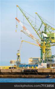 Hoisting cranes in the industrial zone of the Port in Kobe Hyogo Kansai Japan using for import export shipping and global business background