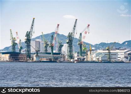 Hoisting cranes in the industrial zone of the Port in Kobe Hyogo Kansai Japan using for import export shipping and global business background