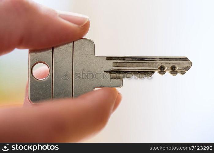 Holding a house key in the hand: New home and property.